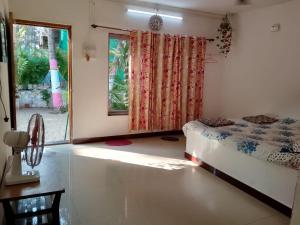 a bedroom with a bed and a window and a table at Holiday Homestay Beach Rooms Deep Diving & Light House & Watersports Tarkarli in Bhogwe