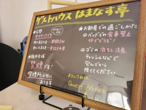 a chalkboard sign with chinese writing on it at ゲストハウスはまなす亭 in Jōnai