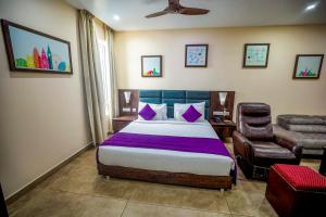 a bedroom with a bed and a chair at Anna Residency The Quintessential Boutique Hotel in Pondicherry