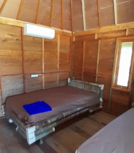 a bed in a room in a cabin at anisa homestay and restaurant in Ekas