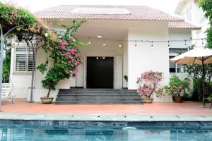 a house with a swimming pool and flowers at Tigon Villa in Mỹ Ðuc