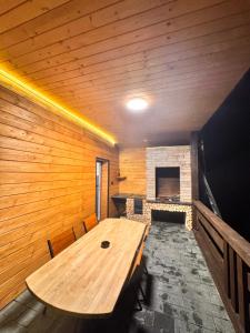 a large wooden table in a room with a fireplace at Apartamenty Lisovychok in Richka