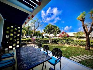 a table and chairs on a patio with a garden at 719 - Villa Oceanami - Phước Hải in Long Hai