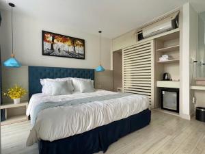 a bedroom with a large bed with a blue headboard at 719 - Villa Oceanami - Phước Hải in Long Hai +2 photos