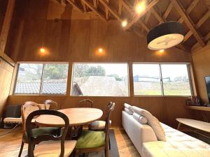 a dining room with a table and a couch at SUMITSUGU HOUSE Atelier in Kumamoto