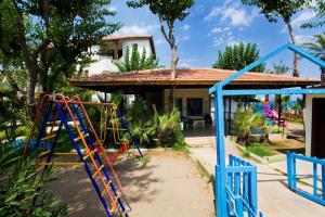 a playground in front of a house at Marvıda Hotel Akman Park in Kemer