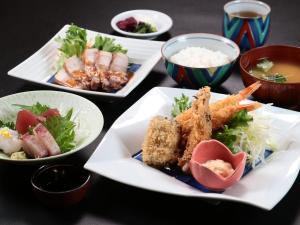 a table with plates of food and bowls of food at 港の魚宿 おおそね in Owase