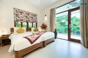 a bedroom with a large bed and a large window at Acron Waterfront Resort in Baga +94 photos