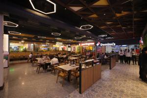 a restaurant with people sitting at tables in a mall at The Mars Resorts in Meerut