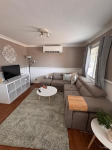 a living room with a couch and a table at Singleton Rose Cottages in Singleton
