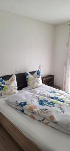 a bed with a comforter and pillows on it at Gasthof Moosmatt in Egolzwil
