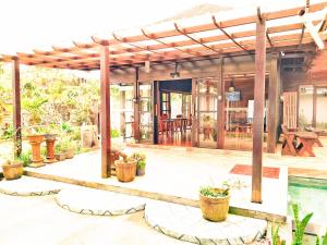 an outdoor patio with a pergola and a pool at Merlyn Meadows Retreat in Munduk