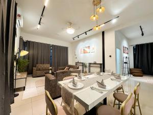 a dining room and living room with a table and chairs at Kulim Modern Bungalow in Kulim