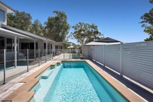 a swimming pool in the backyard of a house at The Banksia's in Tea Gardens