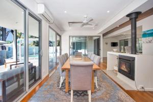 a dining room with a table and a fireplace at The Banksia's in Tea Gardens