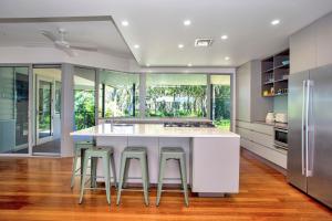 a kitchen with a large white island with bar stools at The Banksia's in Tea Gardens