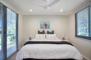 a bedroom with a large bed and two windows at The Banksia's in Tea Gardens +27 photos