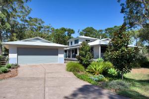 a white house with a garage in a yard at The Banksia's in Tea Gardens