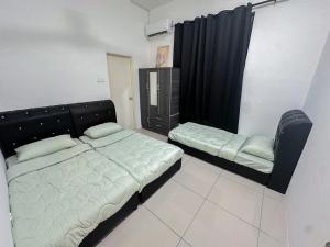 a bedroom with a bed and a chair in it at Kulim Modern Bungalow in Kulim +12 photos