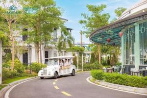 a small white car driving down a road at Vườn vua thanh thuỷ in Ðồng Phú