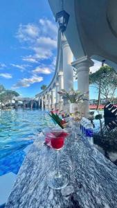 a wine glass sitting on a table next to a swimming pool at Vườn vua thanh thuỷ in Ðồng Phú