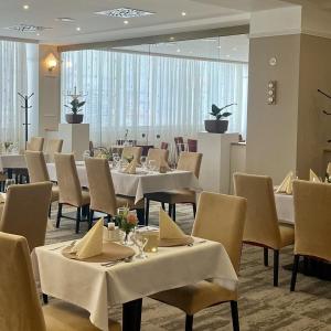 a dining room with white tables and chairs at Hotel Zlatý Býk in Rimavská Sobota +53 photos