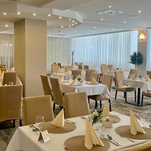 a dining room with white tables and chairs at Hotel Zlatý Býk in Rimavská Sobota
