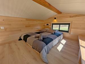 a bedroom in a log cabin with a large bed at La Parenthèse Romantique in Saint-Martin-de-la-Mer