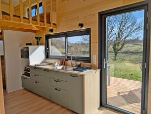 a kitchen in a tiny house with a large window at La Parenthèse Romantique in Saint-Martin-de-la-Mer +15 photos
