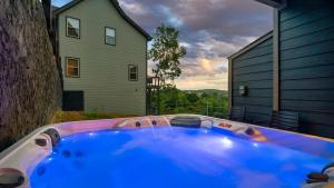 a jacuzzi tub in a yard with a house at Jolene- Cabin Goals, Best Location, Pool & Hot Tub, Dogs! in Sevierville