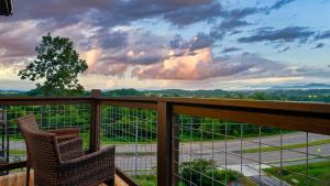 a balcony with two chairs and a view at Jolene- Cabin Goals, Best Location, Pool & Hot Tub, Dogs! in Sevierville