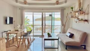 a living room with a couch and a table and a dining room at Secret Place in Panwa Beach