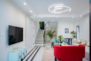 a living room with a red couch and a tv at Villa Aura in Siliguri