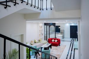 a living room with a red chair and a couch at Villa Aura in Siliguri