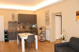 a living room with a table and a kitchen at Borgese Apartments in Palermo