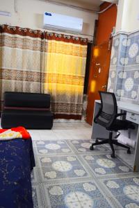 a room with a bed and a desk and a chair at Kompass - Home Stay in Dhaka