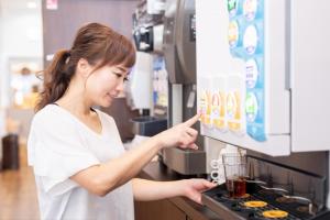 a woman in a kitchen putting food into a blender at Tetora Higashimuroran in Muroran