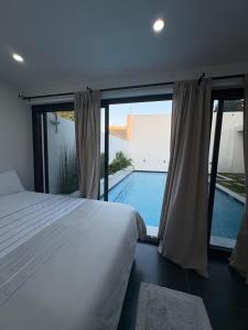 a bedroom with a large bed and a swimming pool at Coastal Beach Apartments in Maputo +68 photos