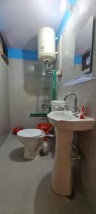 a bathroom with two sinks and a toilet and a light at Beyond Rohtang in Tāndi