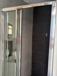 a shower with a glass door in a bathroom at Coastal Beach Apartments in Maputo