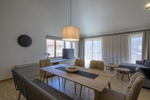 a dining room and living room with a table and chairs at Alpensonne Apartments in Bad Wiessee