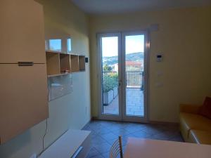 a kitchen with a door to a balcony with a view at Casa Rita in Civezza +11 photos