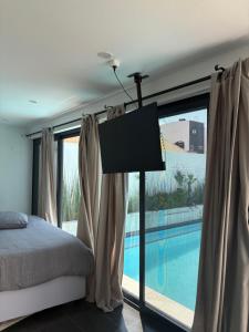 a bedroom with a bed and a swimming pool at Coastal Beach Apartments in Maputo