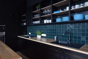 ブダペストにあるLuxury Apartment by Hi5 - Bajcsy Suiteの緑のタイル張りの壁、シンク付きのキッチンが備わります。