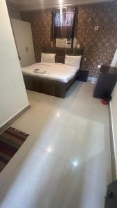 a bedroom with a bed and a white floor at Jai Shree Hotel in Noida