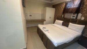 a bedroom with a large bed with white sheets at Jai Shree Hotel in Noida