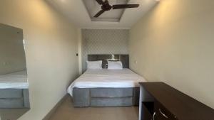 a bedroom with two beds and a ceiling fan at Jai Shree Hotel in Noida