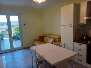 a kitchen and living room with a table and a couch at Casa Rita in Civezza