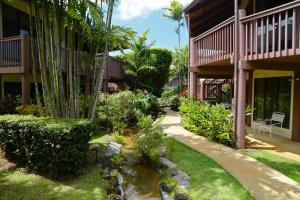 a garden in front of a building with a pond at Club Wyndham Ka Eo Kai in Princeville