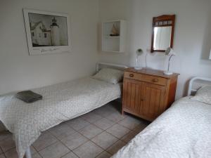 a bedroom with two beds and a wooden dresser at The Beach House, Kangaroo Island in Baudin Beach +3 photos